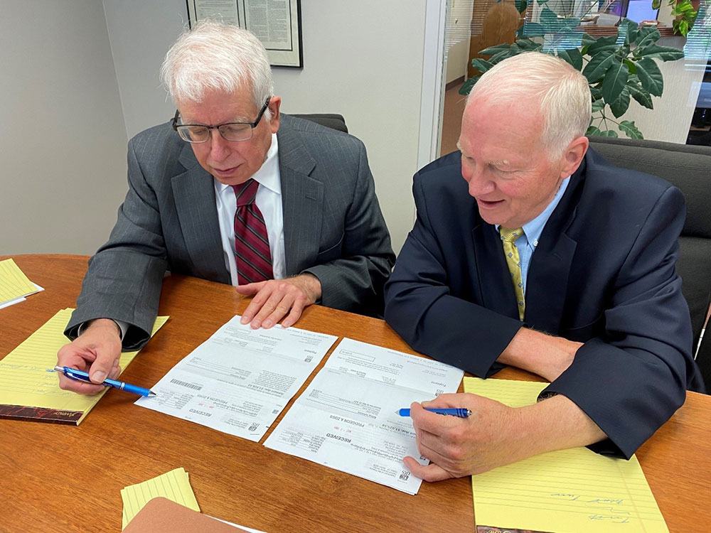 Two Minnesota Attorneys at Pridgeon & Zoss, PLCC Look Over Tax Law Documents. 